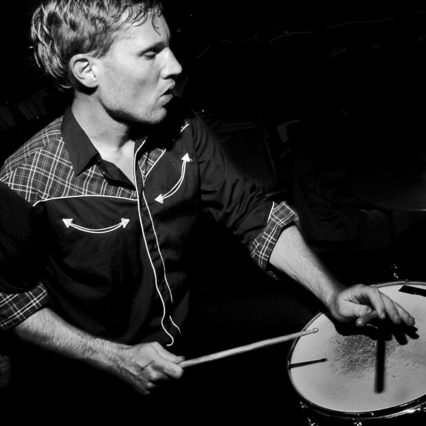 A man plays drums intensely in a dark setting, HD Desktop Wallpaper
