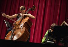 Female cellist playing classical music on stage.