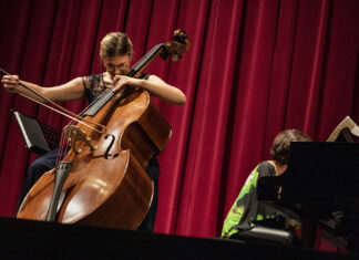 Female cellist playing classical music on stage.