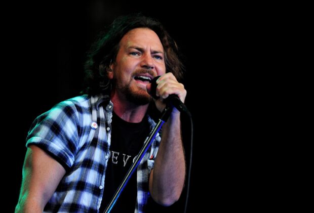 The Pearl Jam lead singer passionately sings into the microphone on stage during a concert, 2K Desktop Wallpaper