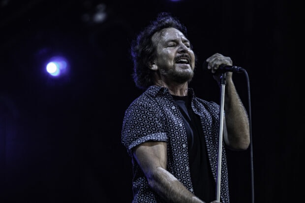 A male singer passionately performing live on stage with a microphone stand during a concert, HD Desktop Wallpaper