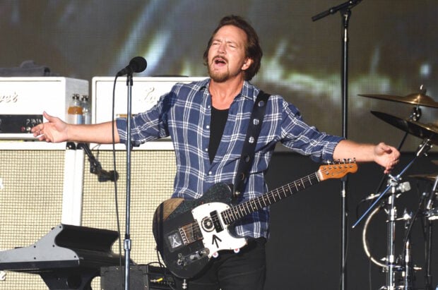 The Pearl Jam lead singer passionately performing live with guitar on stage, 2K Desktop Wallpaper
