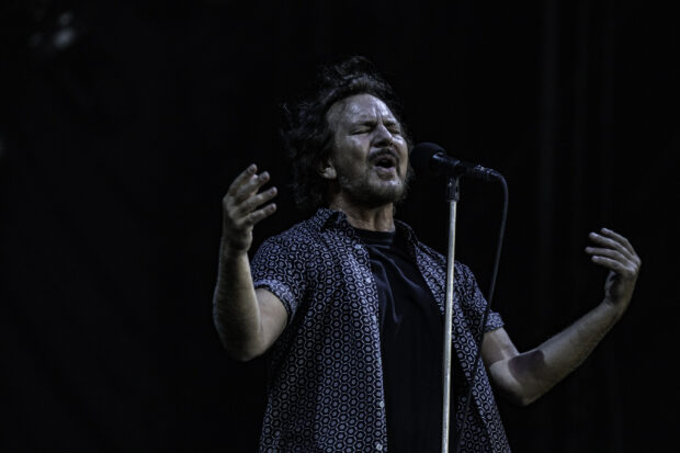 A singer passionately performing on stage during a Pearl Jam concert, HD Desktop Wallpaper