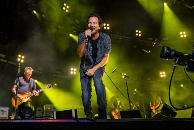 Pearl Jam performs energetically during a concert with vibrant lighting, HD Desktop Wallpaper