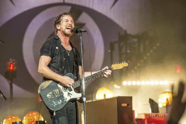 A Pearl Jam artist sings and plays guitar passionately during a concert, 2K Desktop Wallpaper