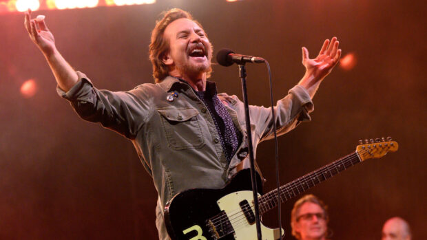 A Pearl Jam singer joyfully performing with guitar during concert, 2K Desktop Wallpaper
