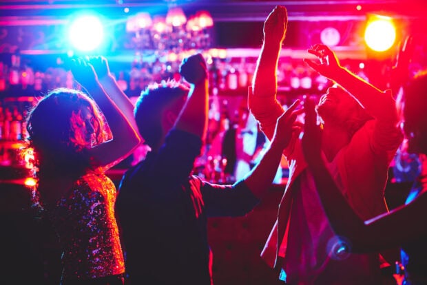 People enjoying energetic nightclub dance party with colorful lighting effects, 2K Desktop Wallpaper