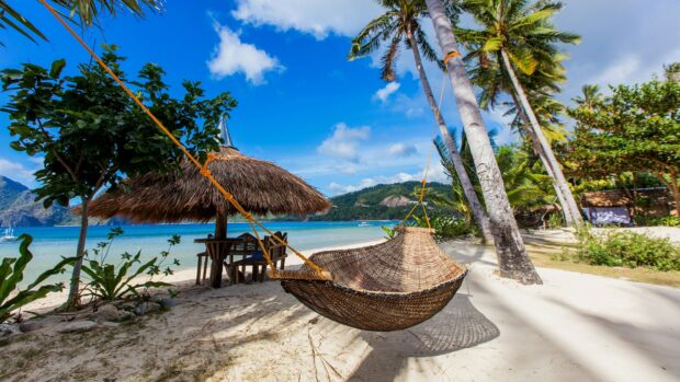 A relaxing beach scene with a hammock and tropical plants in Philippines