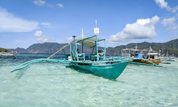 Traditional bangka boat on clear shallow water in the Philippines