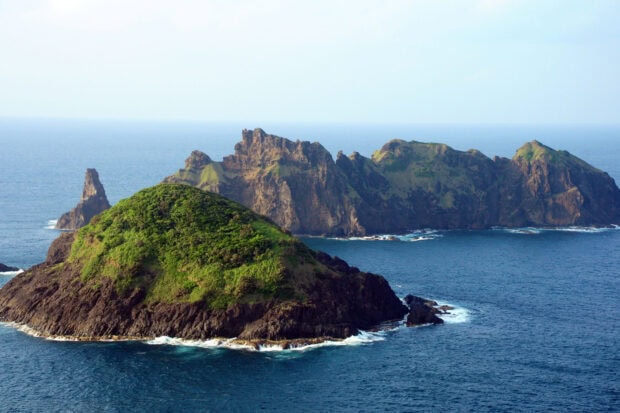 A scenic view of islands with lush greenery and rocky cliffs in the Philippines ocean