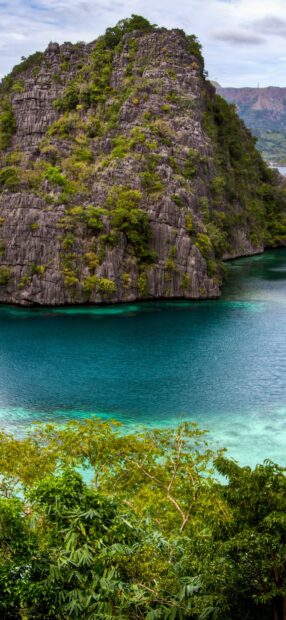 Limestone cliffs and lush greenery surrounding turquoise waters in Philippines