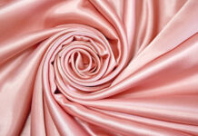 A close up view of pink silk fabric folded in a spiral pattern showing smooth texture, HD Desktop Wallpaper