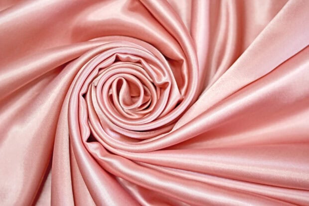 A close up view of pink silk fabric folded in a spiral pattern showing smooth texture, HD Desktop Wallpaper