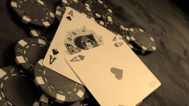 A set of poker chips with three aces cards on a table poker