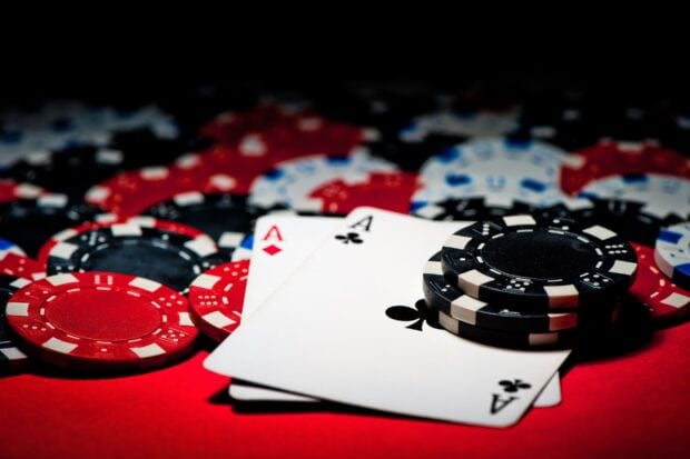 Two aces and poker chips on a red table with a poker game theme