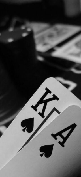 A close up view of poker cards showing king and ace of spades in a poker game setting