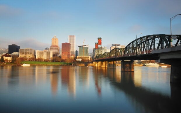 Portland skyline with the Hawthorne Bridge over the calm river at sunset