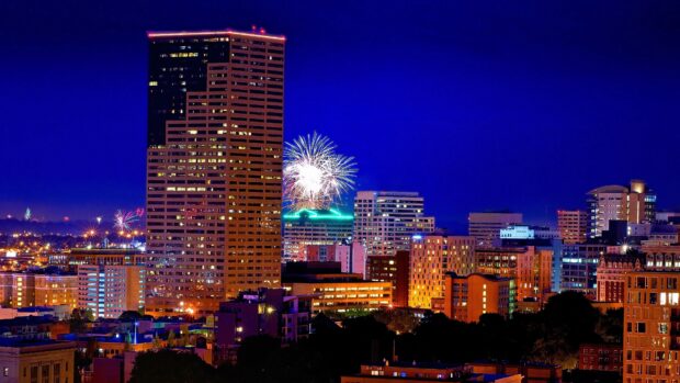 Nighttime Portland skyline with fireworks over the city buildings and illuminated towers