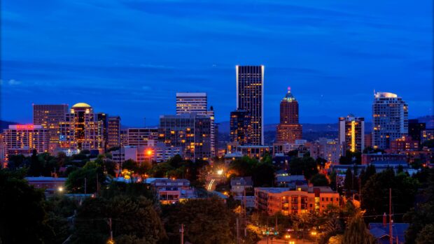 Portland skyline at dusk with illuminated buildings and vibrant city lights