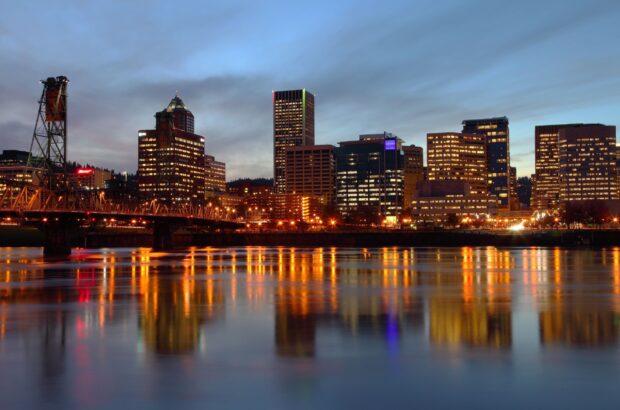 Portland skyline illuminated at dusk with reflections on the river
