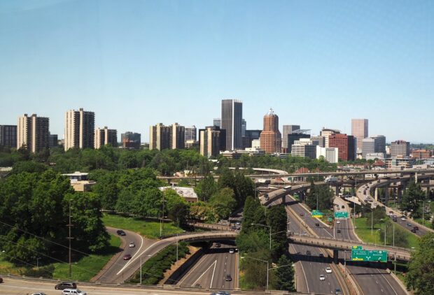 A vibrant view of Portland skyline with highways and lush greenery in clear daylight