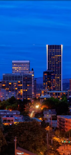 Evening view of Portland skyline with lit buildings and streets at night