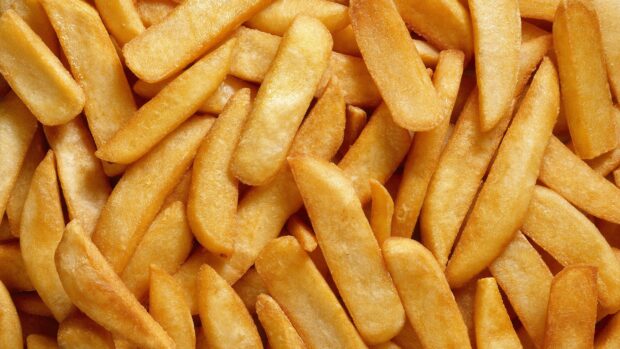 Close up of crispy golden potato fries stacked together