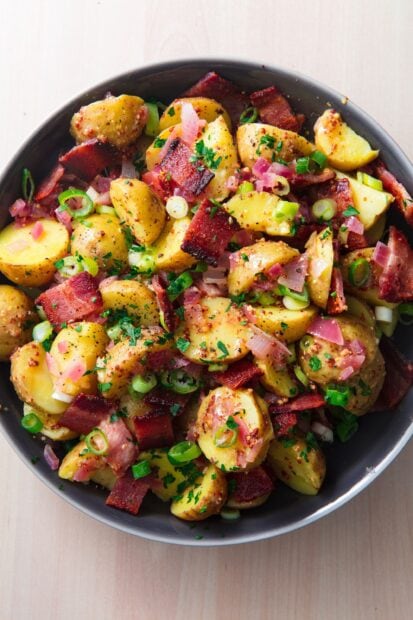 Delicious potato dish with bacon and herbs served in a bowl