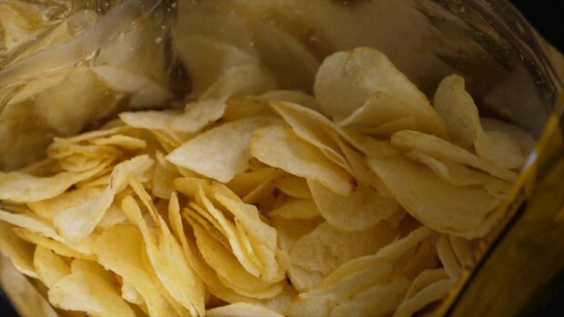 Close up of potato chips inside a bag showing crispy potato slices