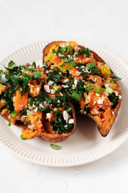 Baked potato filled with kale and quinoa served on a white plate