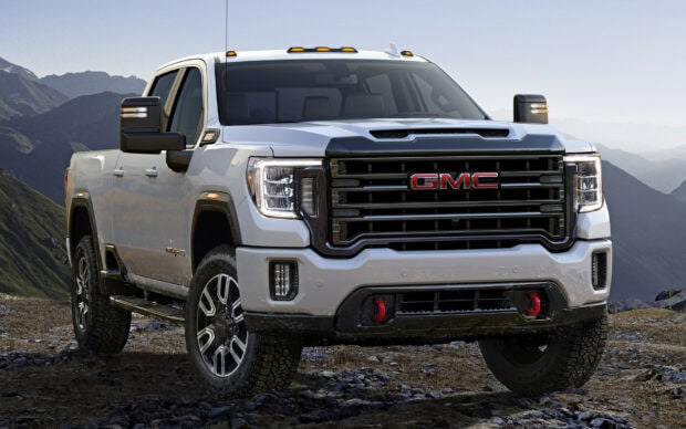 A white GMC truck stands on rocky ground with mountains in the background, HD Desktop Wallpaper