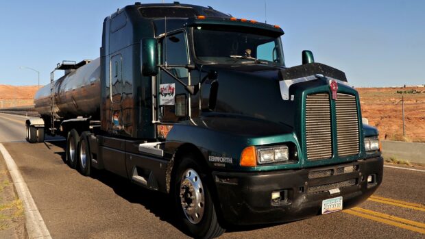 A Kenworth truck is driving on a sunny highway with a desert backdrop, HD Desktop Wallpaper