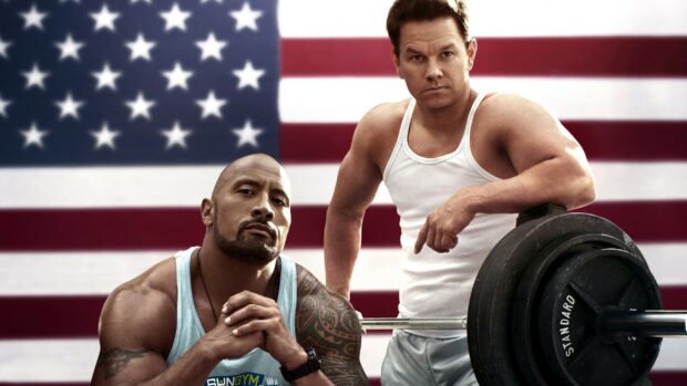 Two men showing powerlifting strength and focus in front of an American flag, 2K Desktop Wallpaper