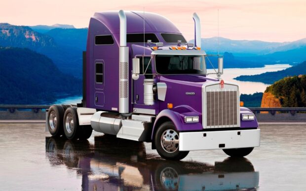 A purple Kenworth truck is parked on a wet surface with mountains and river in the background, 2K Desktop Wallpaper