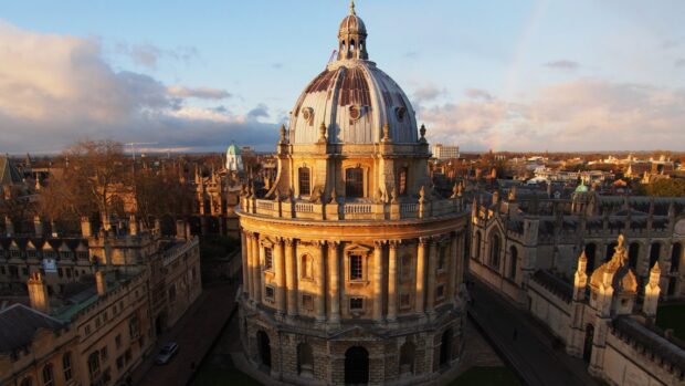 The Radcliffe Camera stands prominently at Oxford University under a partly cloudy sky during sunset, HD Desktop Wallpaper