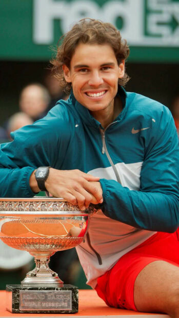 Rafael Nadal smiles while holding the Roland Garros trophy after a match, HD Phone Wallpaper