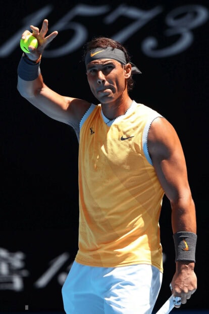 Rafael Nadal is preparing to serve the ball during a match in a sleeveless yellow shirt, HD Desktop Wallpaper