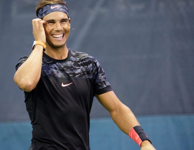 Rafael Nadal is smiling and adjusting his headband during tennis training, HD Desktop Wallpaper