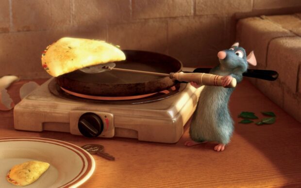 Ratatouille cooking a stuffed pancake on a skillet in a kitchen setting