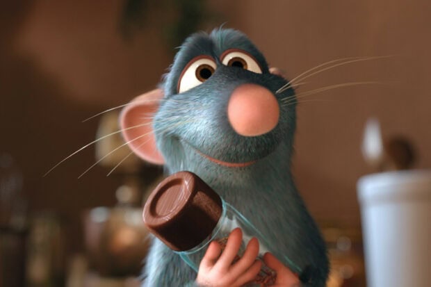 Ratatouille holding a spice container with a joyful expression in a kitchen setting