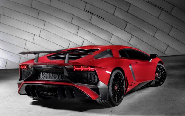 Một chiếc xe thể thao Lamborghini màu đỏ được đỗ trong nhà dựa vào bức tường cong bằng kim loại, thể hiện thiết kế bóng bẩy của nó trong Hình nền LP, Hình nền máy tính HD