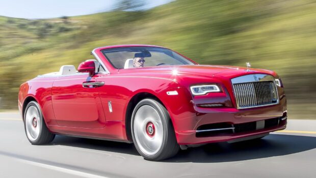 A red Rolls Royce Dawn is captured driving on a highway with blurred greenery in the background, HD Desktop Wallpaper