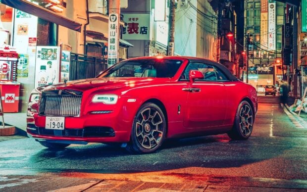 A red Rolls Royce Dawn is parked on a wet city street at night with lights reflecting on the pavement, HD Desktop Wallpaper