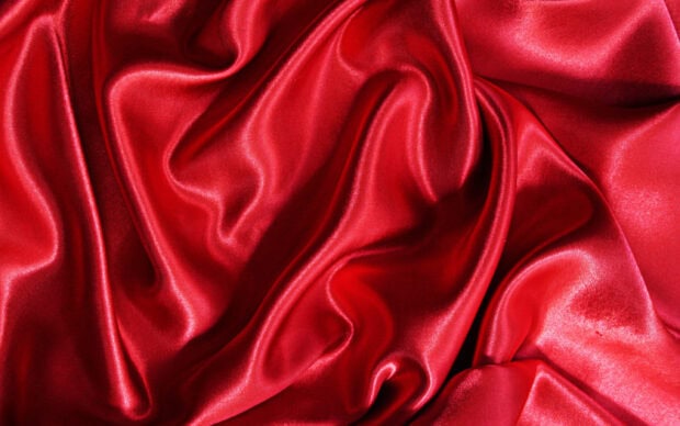 The red silk fabric displays smooth folds and a shiny surface in the image, 2K Desktop Wallpaper