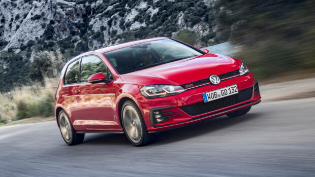 Một chiếc Volkswagen Golf GTI màu đỏ đang chạy nhanh trên con đường núi quanh co được bao quanh bởi những ngọn đồi đá, Hình nền máy tính 4K
