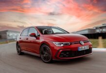 A red Volkswagen Golf GTI is driving on a racetrack during a colorful sunset, 2K Desktop Wallpaper