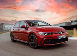 A red Volkswagen Golf GTI is driving on a racetrack during a colorful sunset, 2K Desktop Wallpaper