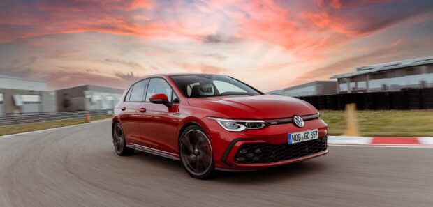 Một chiếc Volkswagen Golf GTI màu đỏ đang chạy trên đường đua trong cảnh hoàng hôn đầy màu sắc, Hình nền máy tính 2K