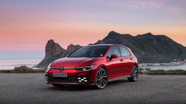 Một chiếc Golf Gti màu đỏ đang đỗ trên một con đường với những ngọn núi và bầu trời hoàng hôn ở phía sau, Hình nền máy tính 4K