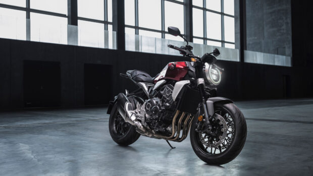 A red and black Honda CB1000R stands inside a modern garage with large windows, 4K Desktop Wallpaper